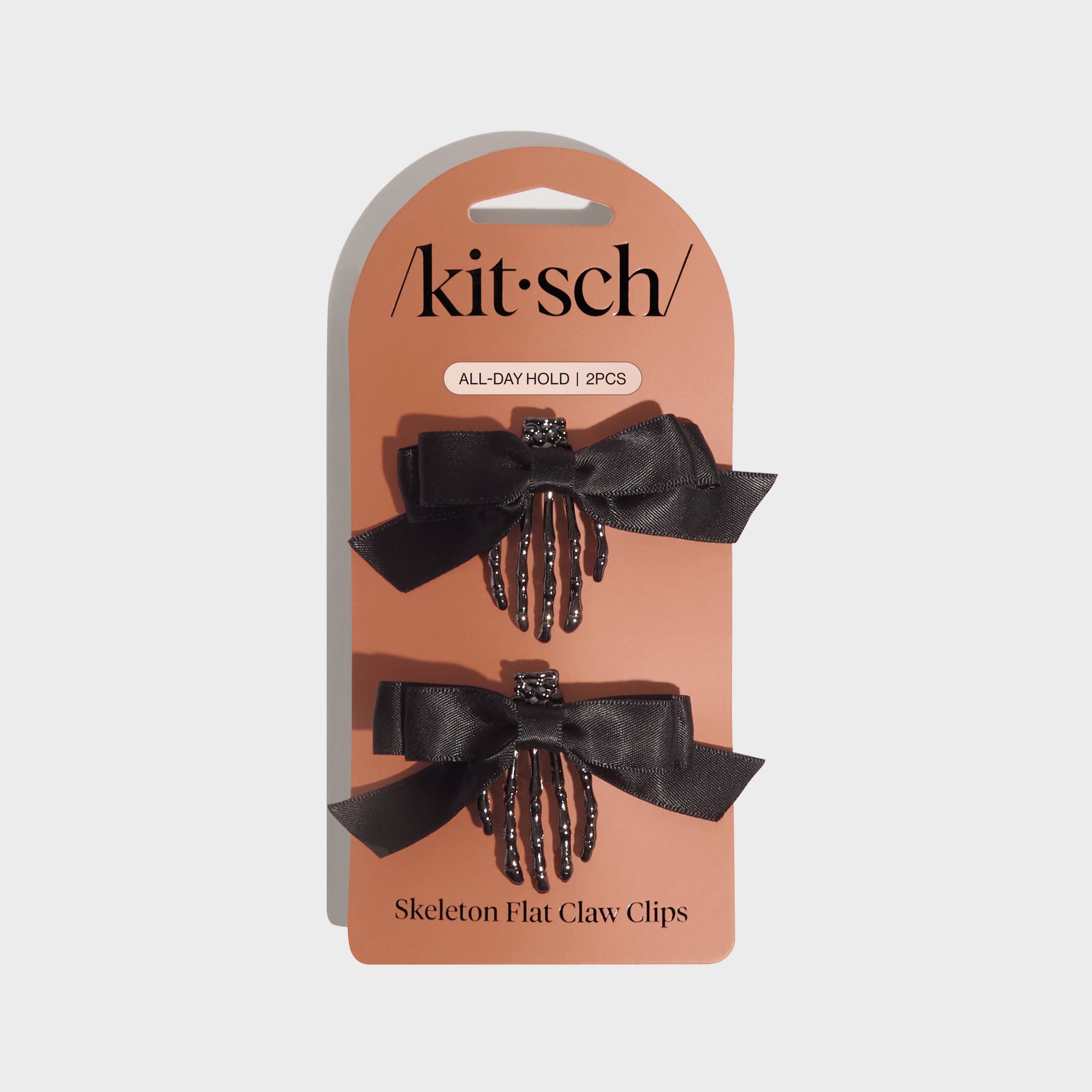 Kitsch skeleton flat claw clips on a branded card with a beige background