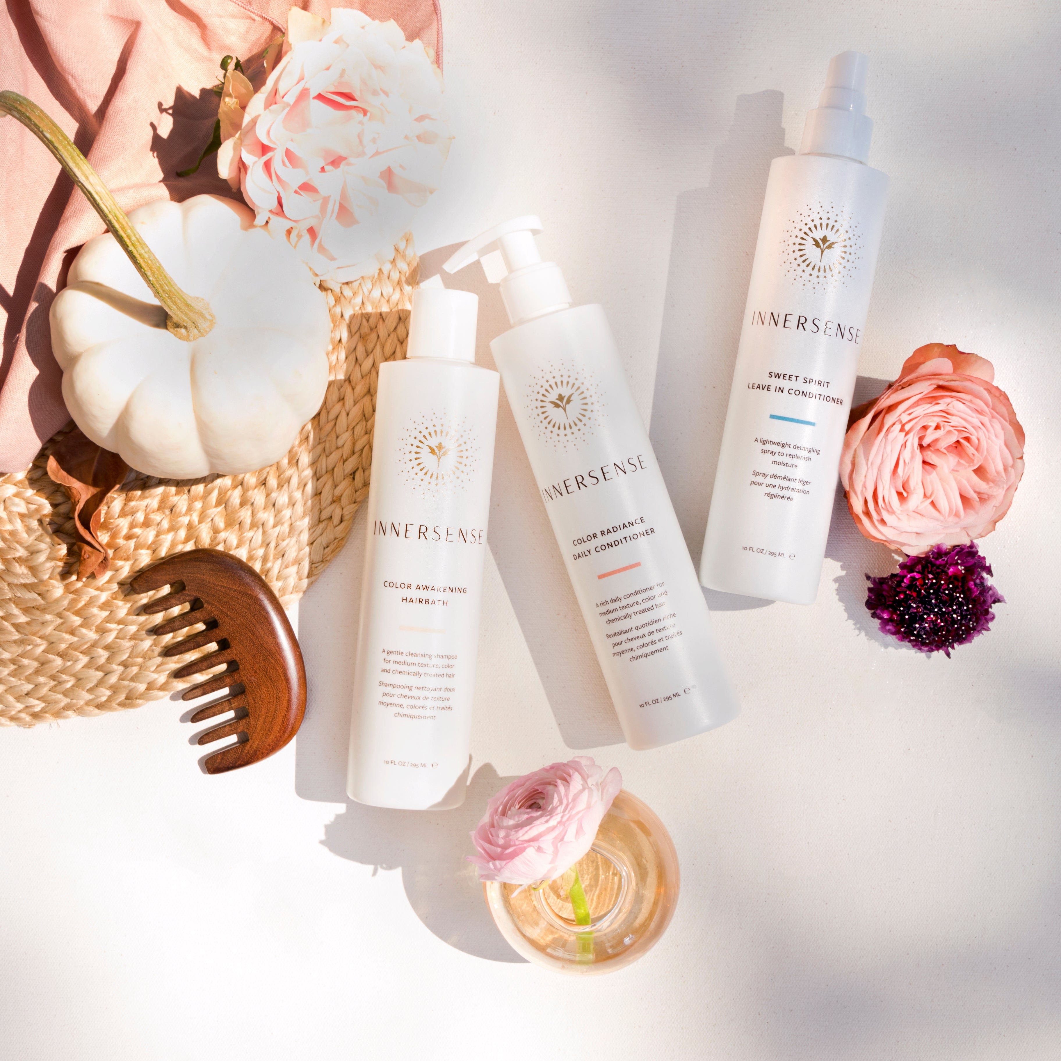 Cosmetic products with flowers and a hat on a light background