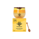 Honey lip balm with packaging and a wooden applicator on a white background