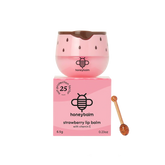 Pink lip balm with strawberry seed design and honeycomb, accompanied by its packaging and a honey stick on a white background.