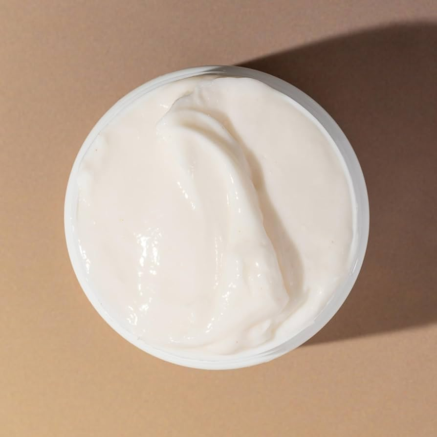 Jar of white avocado and rose clump and define cream on a beige background