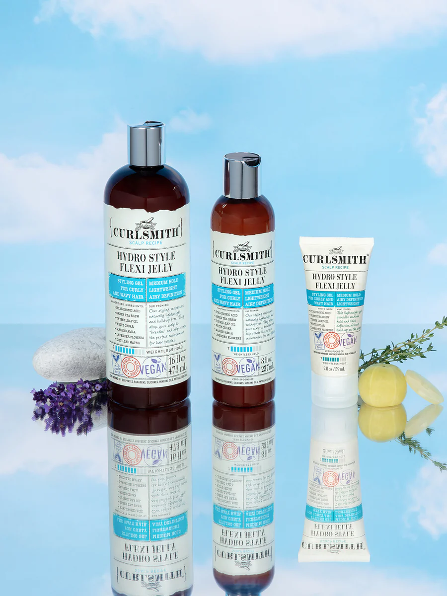 Curlsmith scalp recipe hair care products on a blue background with flowers and stones.