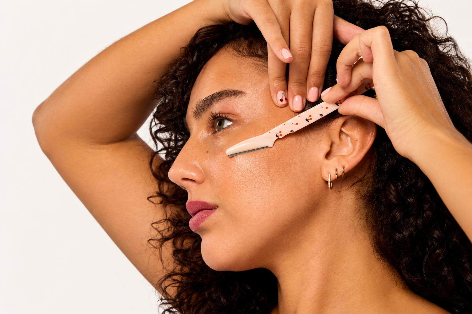 woman using a cherry print dermaplaner 