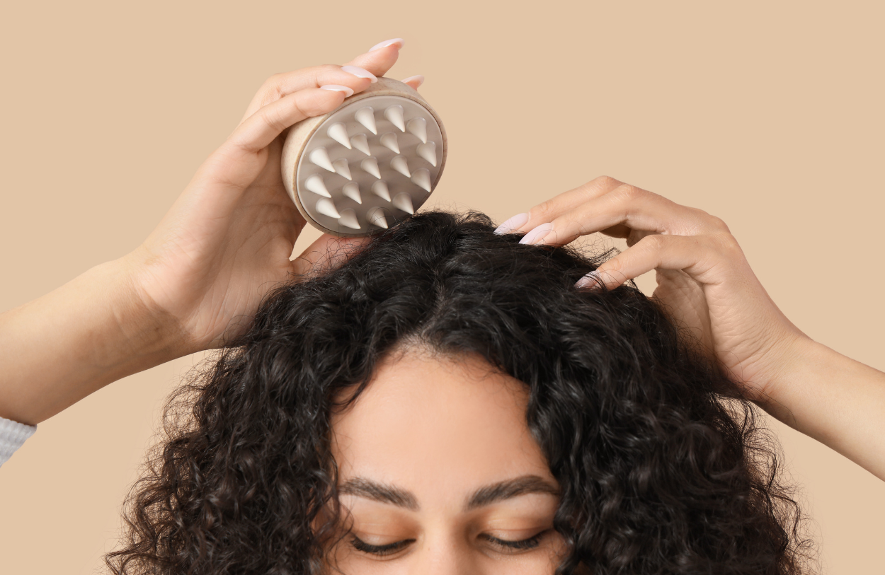 beige scalp massager on curly hair