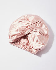 Pink silk bonnet on a light gray background