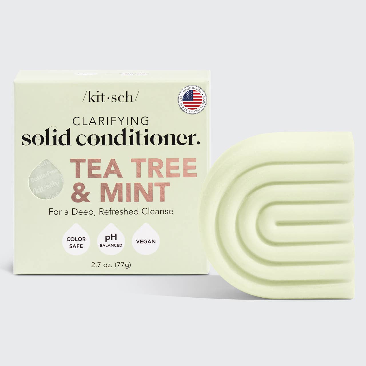 A solid conditioner bar with packaging that reads 'Kitsch Clarifying Solid Conditioner Tea Tree & Mint'. The bar is pale green with the brand name Kitsch at the top.