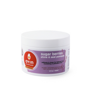 A container of Oyin Handmade Sugar Berries Pomade with the label visible. The container is white with a red and purple label that includes the product name and description.