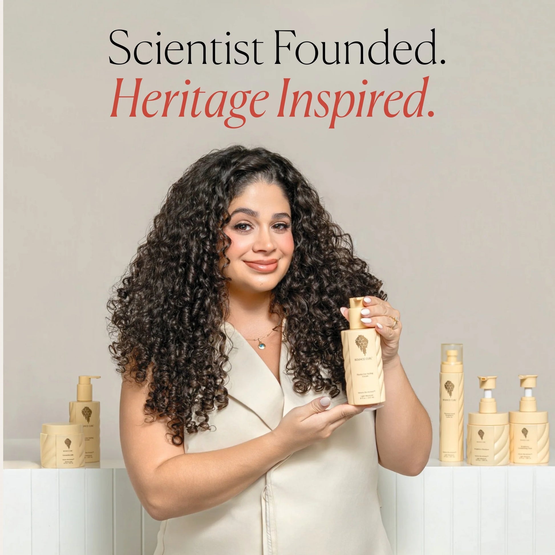 Merian bounce curl holding a product with text 'Scientist Founded. Heritage Inspired.'