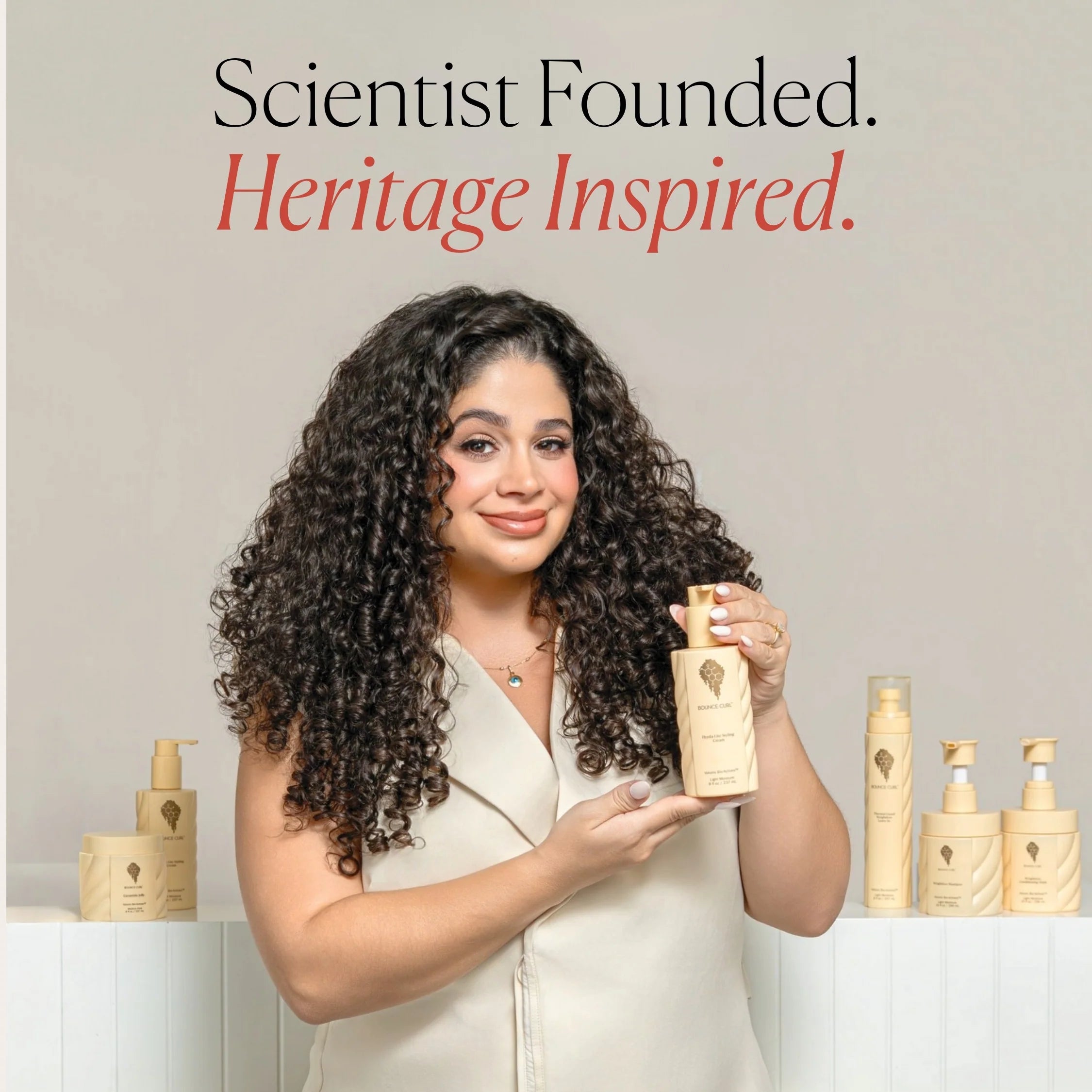 Merian bounce curl holding a product with text 'Scientist Founded. Heritage Inspired.'