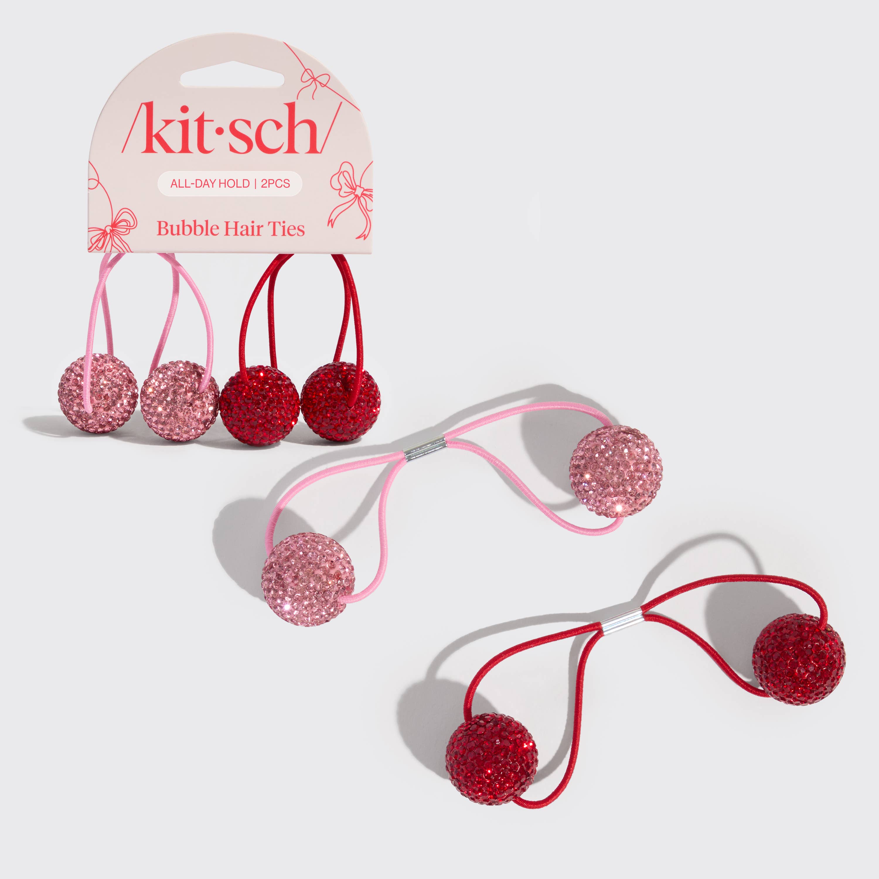 Kitsch bubble hair ties with pink and red glittery bubbles on a white background