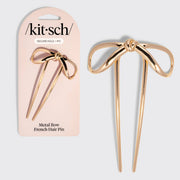 Kitsch Mini Metal Bow French Hair Pin – Gold shown next to its light pink retail packaging card on a light gray background.