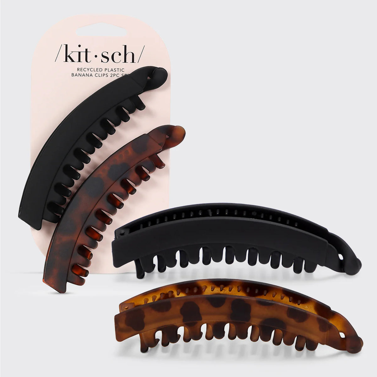 Set of black and tortoiseshell hair clips with 'kit•sch' packaging on a light gray background