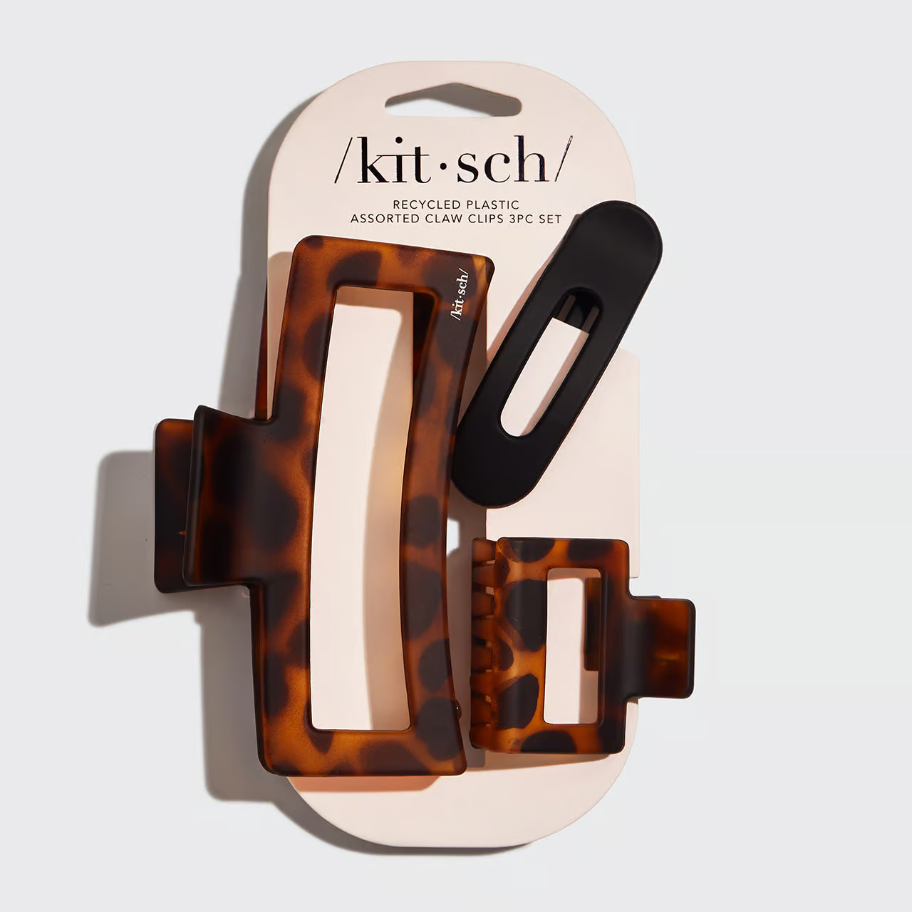 A set of Kitsch brand hair claw clips in assorted sizes and colors, including a tortoise shell pattern, displayed on a packaging card.