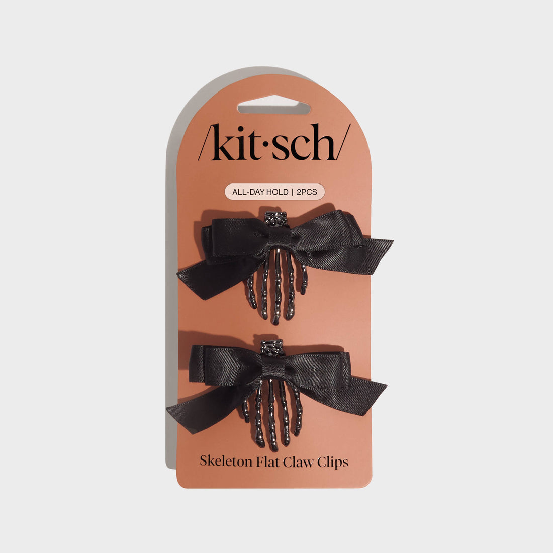 Kitsch skeleton flat claw clips on a branded card with a beige background
