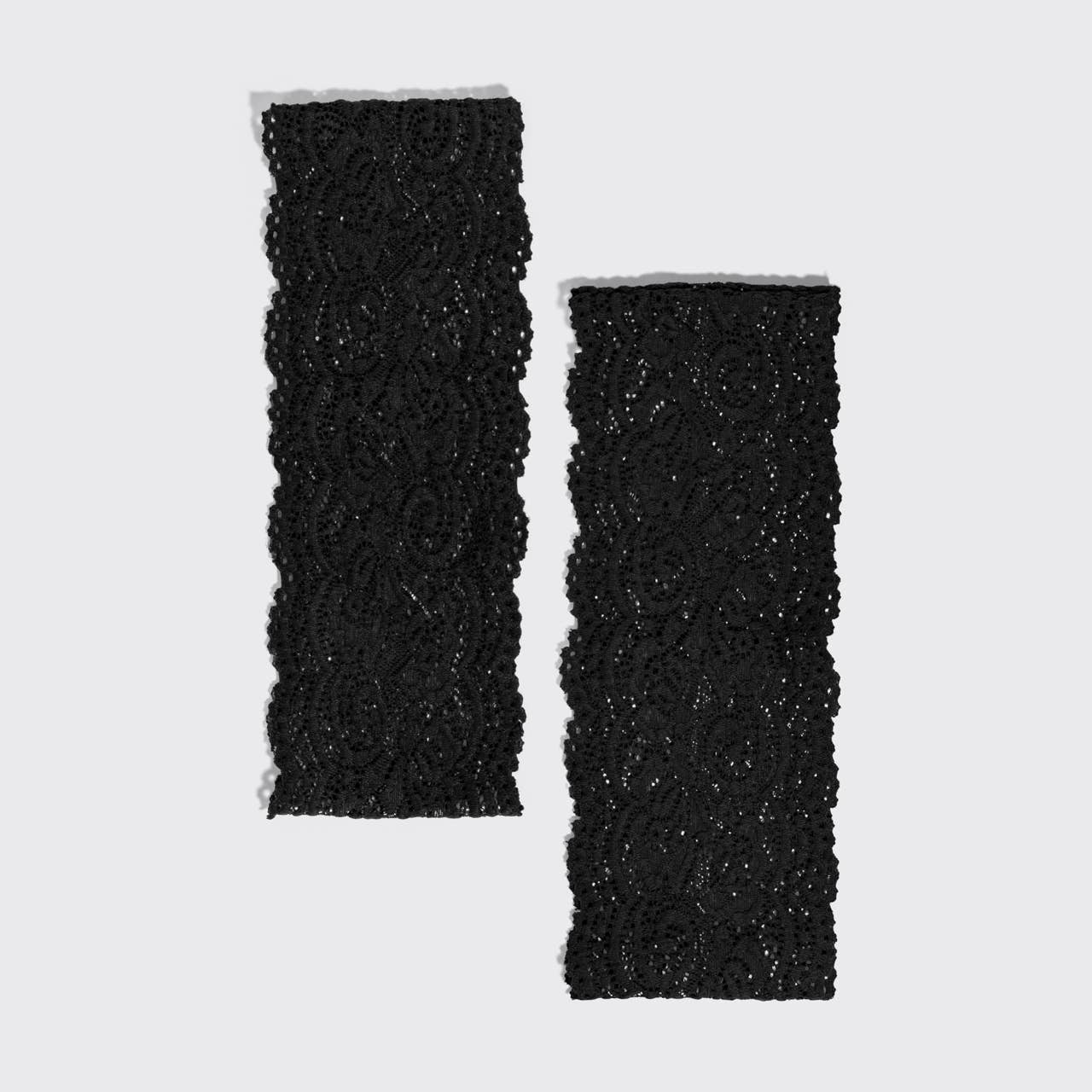 Two black textured fabric kitsch headbands with a floral lace pattern and glittery sequin details, displayed on a light gray background.