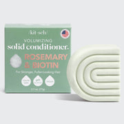 A Kitsch Rosemary & Biotin Volumizing Solid Conditioner Bar next to its packaging, which is labeled as vegan, cruelty-free, and pH balanced.