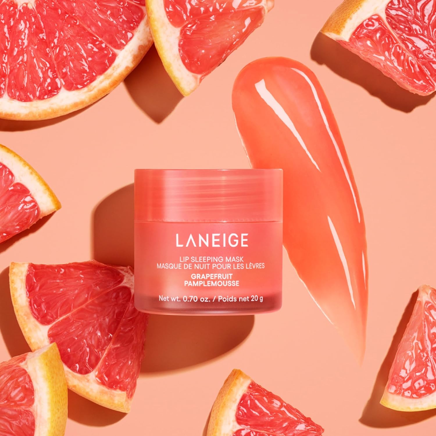 Laneige lip sleeping mask jar surrounded by grapefruit slices on a peach background