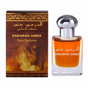 Al Haramain Amber Pure Perfume bottle containing amber-coloured fragrance oil, displayed beside its ornate brown and gold box
