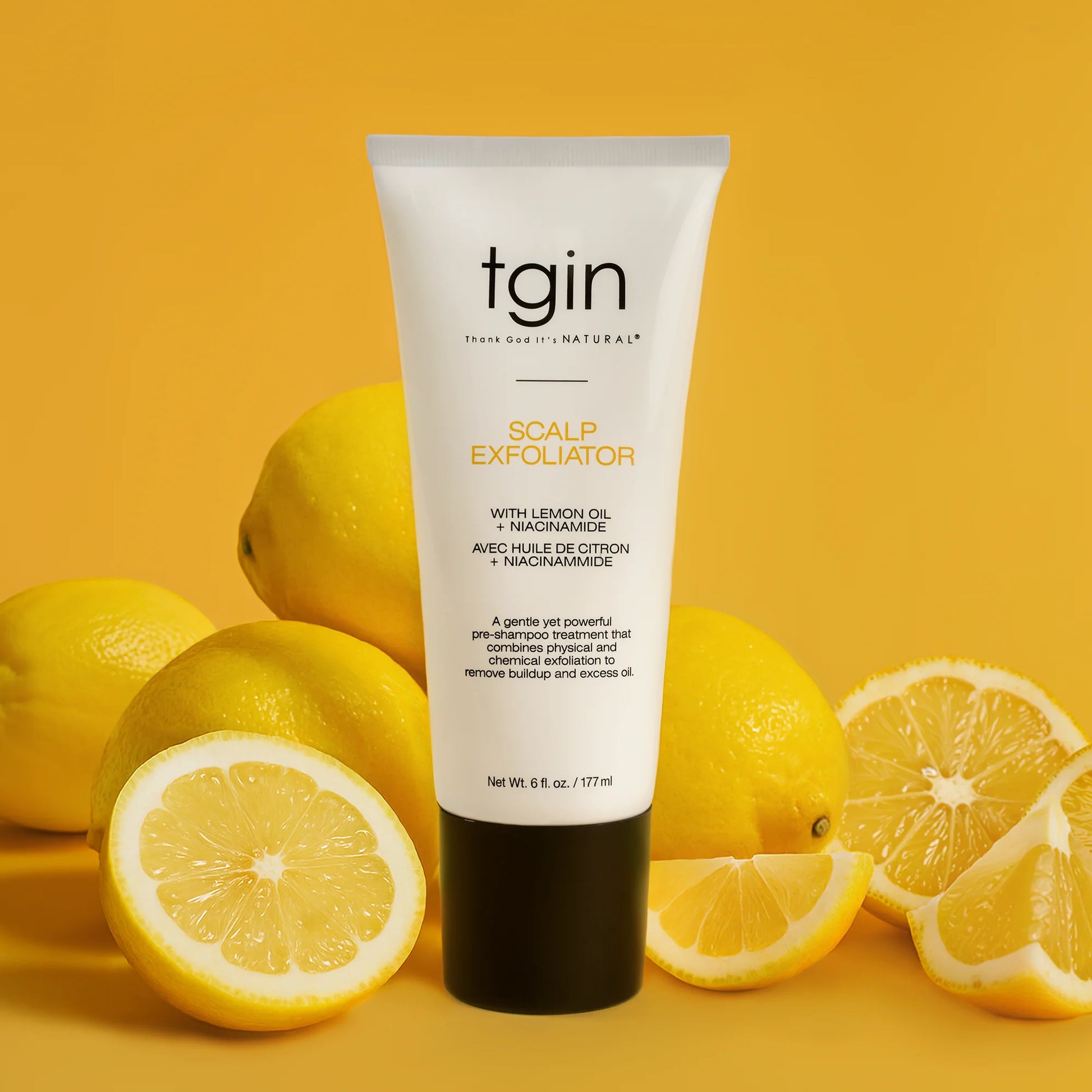 Tube of tgin Scalp Exfoliator with lemons on a yellow background