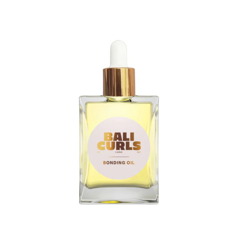 A clear glass bottle with a dropper containing yellow liquid, labeled 'BALI CURLS BONDING OIL'.