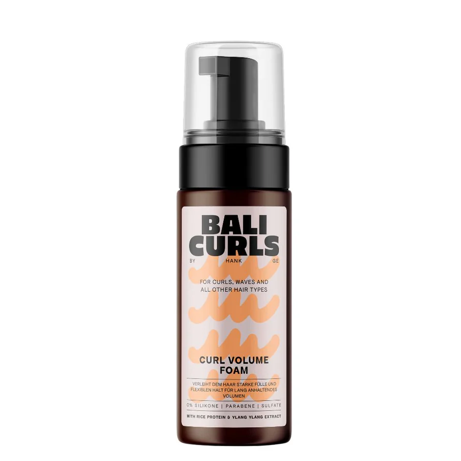 A bottle of Bali Curls Curl Volume Foam with a pump dispenser, predominantly white and orange label, against a white background.