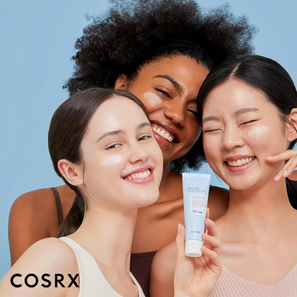 COSRX ultra light invisible sunscreen spf50 pa++++ 50ml group of women smiling with sunscreen tube in hand 