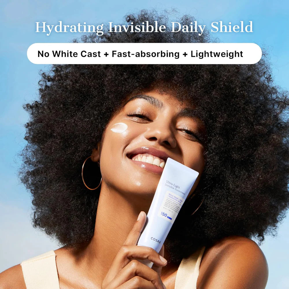 COSRX ultra light invisible sunscreen spf50 pa++++ 50ml woman smiling holding tube, no white cast, fast absorbing and light weight.