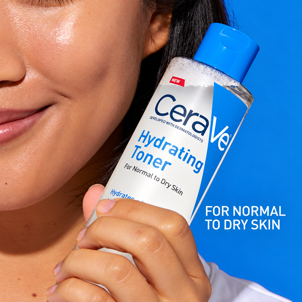 A close-up of a person holding a bottle of CeraVe Hydrating Toner against a bright blue background. The person's face and hand are visible, and the product bottle is clearly shown with its blue cap and white label.
