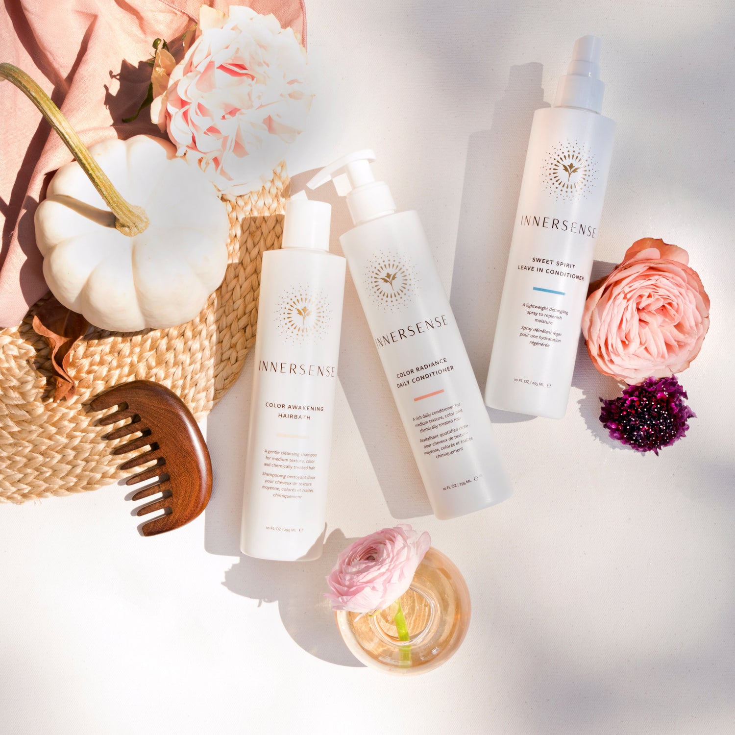 Cosmetic products with flowers and a hat on a light background