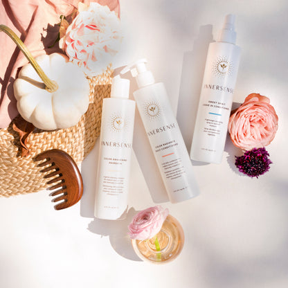 Cosmetic products with flowers and a hat on a light background