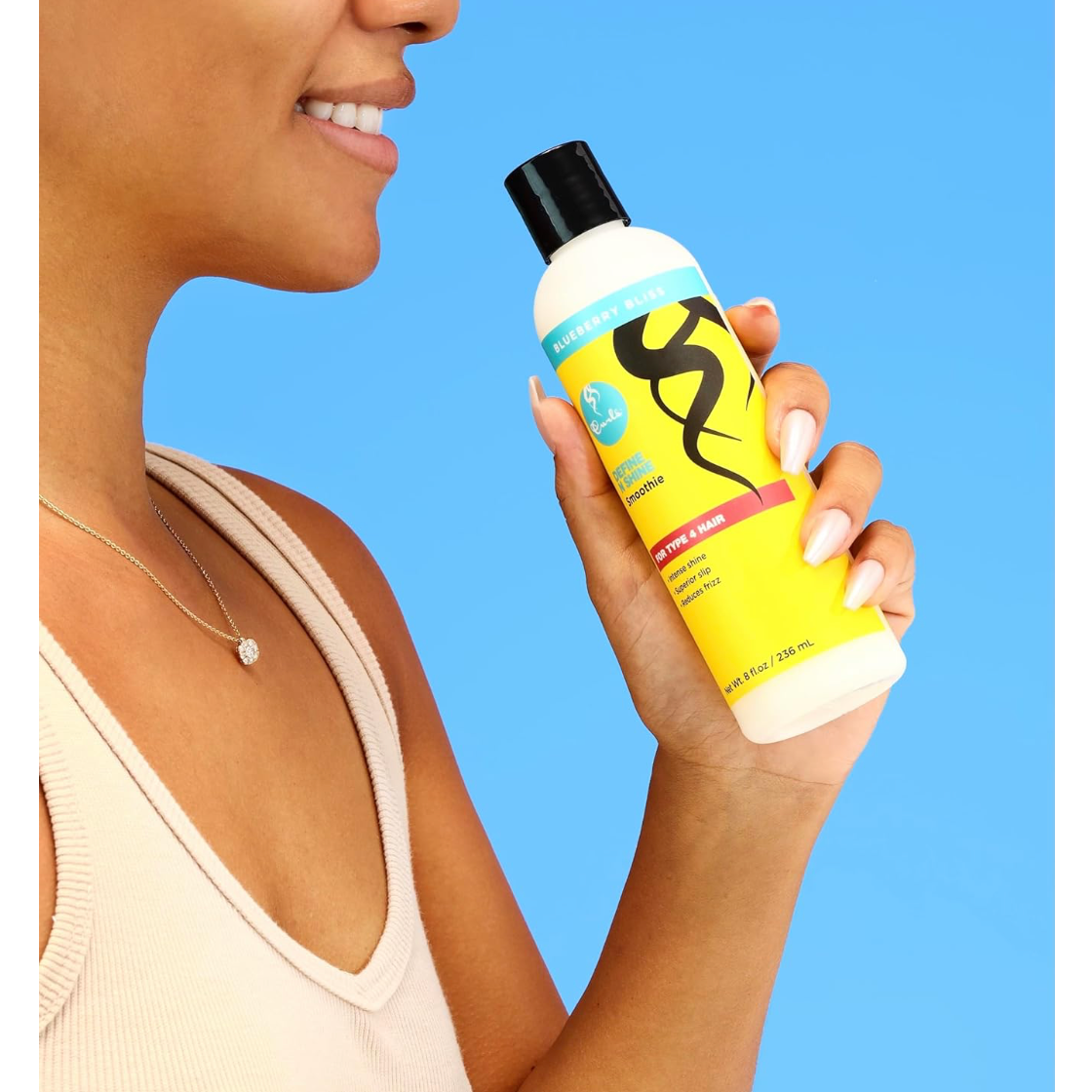Model holding Curls Blueberry Bliss Define N Shine Smoothie 236ml, showcasing the leave-in styling cream for Type 4 hair.