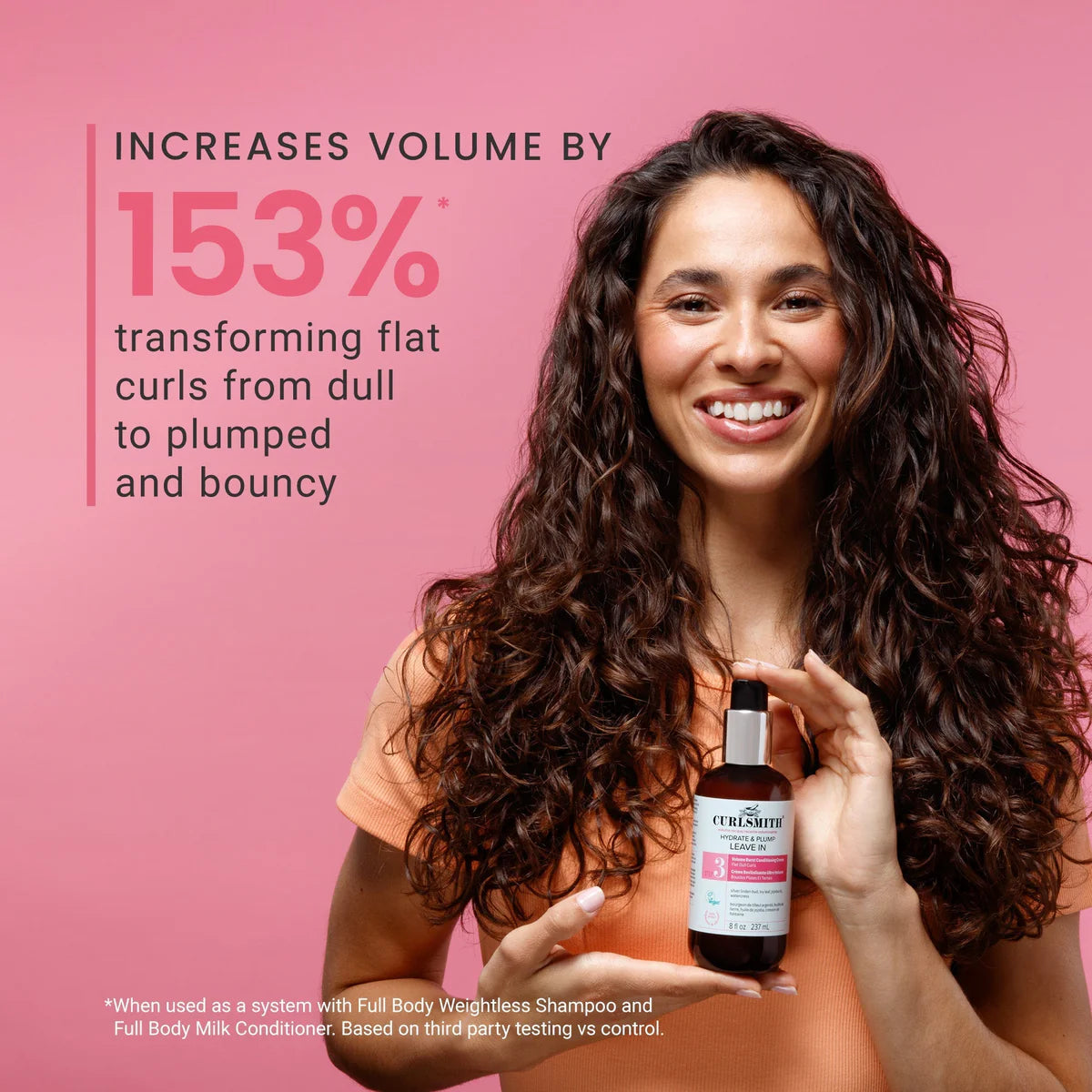 Woman with long, defined curls holding Curlsmith Hydrate & Plump Leave-In 8oz / 237ml, a lightweight volumising conditioning cream that transforms flat, dull curls into fuller, plumper and bouncier hair