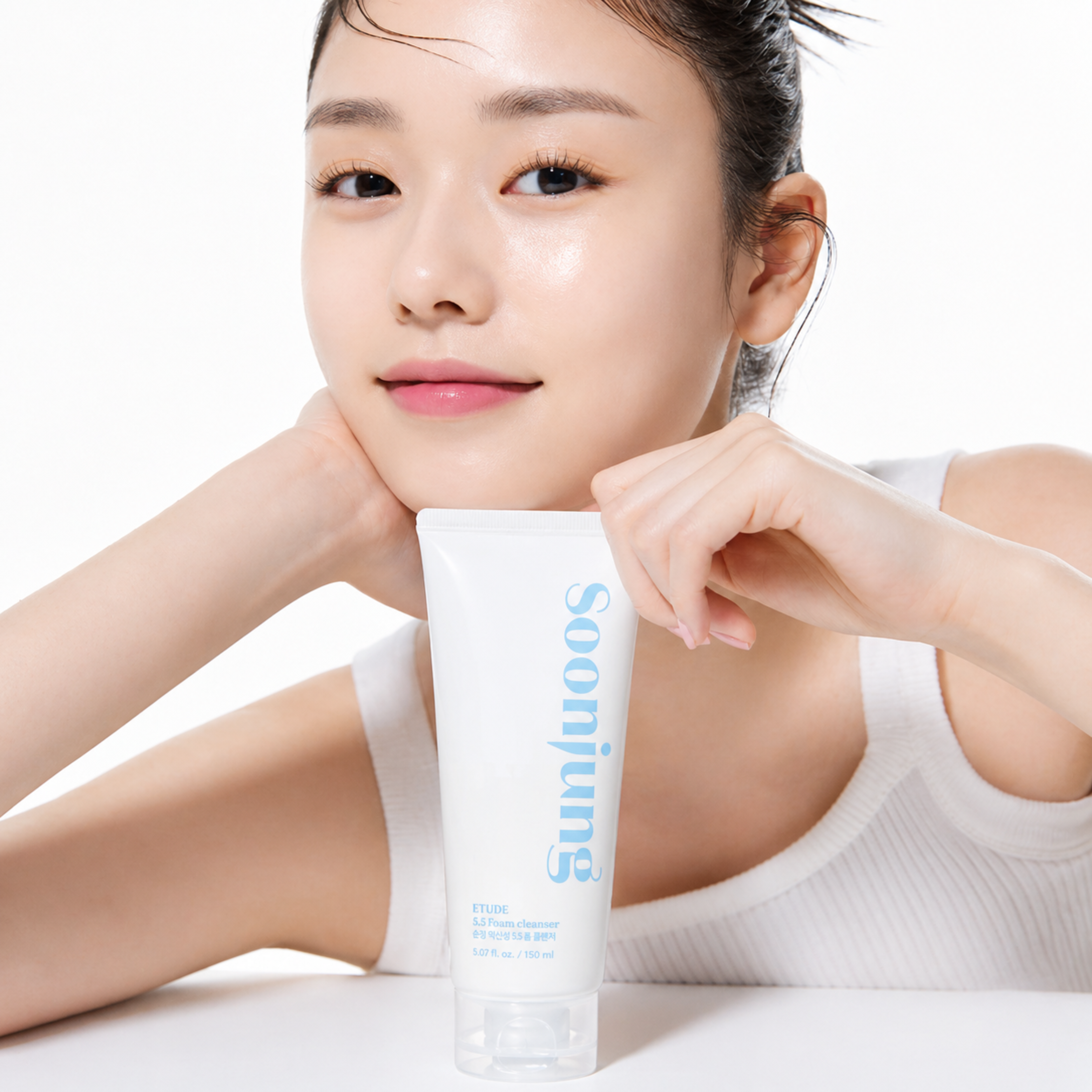Woman holding a skincare product with 'Soomjung' branding on a white background