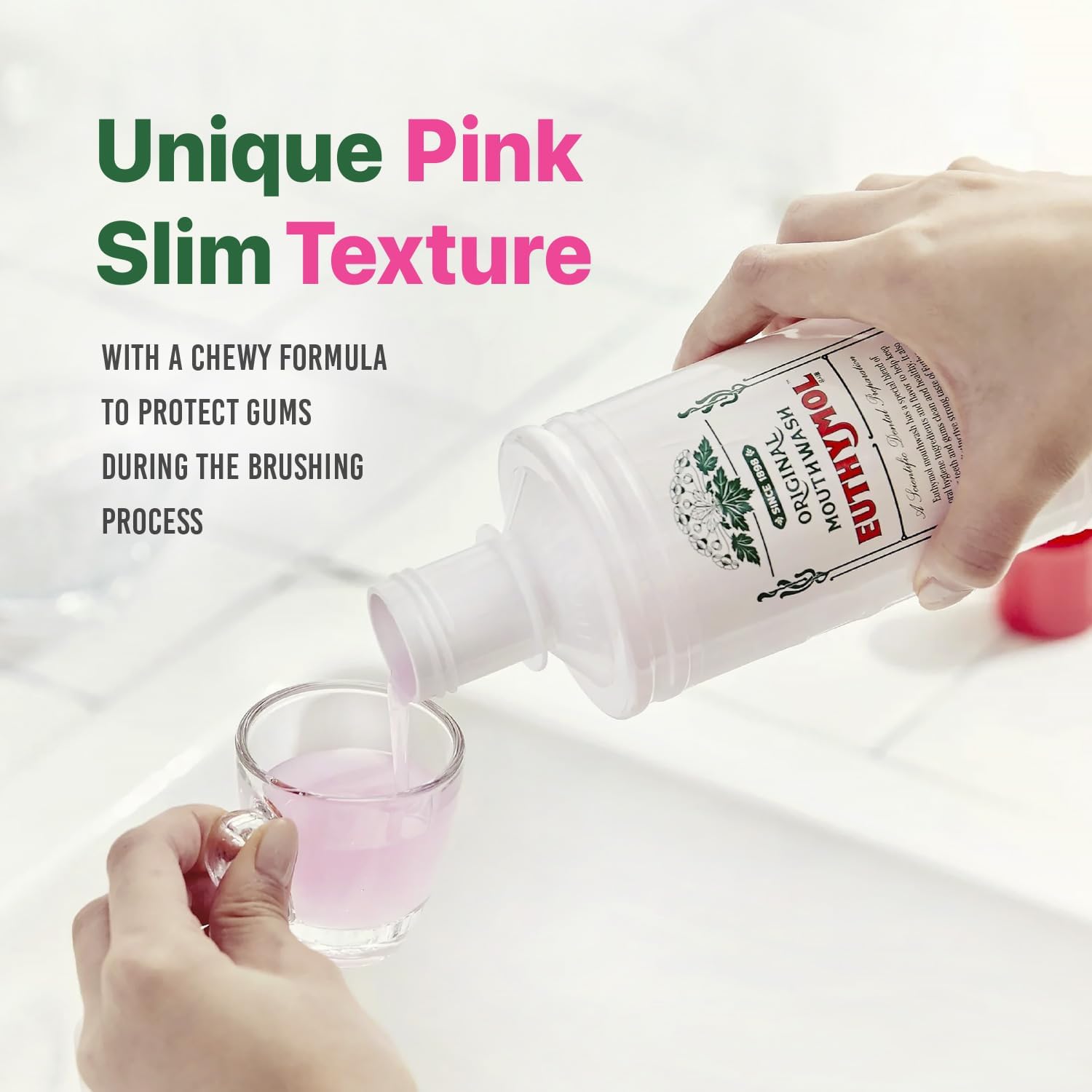 White Euthymol mouthwash bottle pouring pink mouthwash into a glass against a bright bathroom background, showing its slim texture