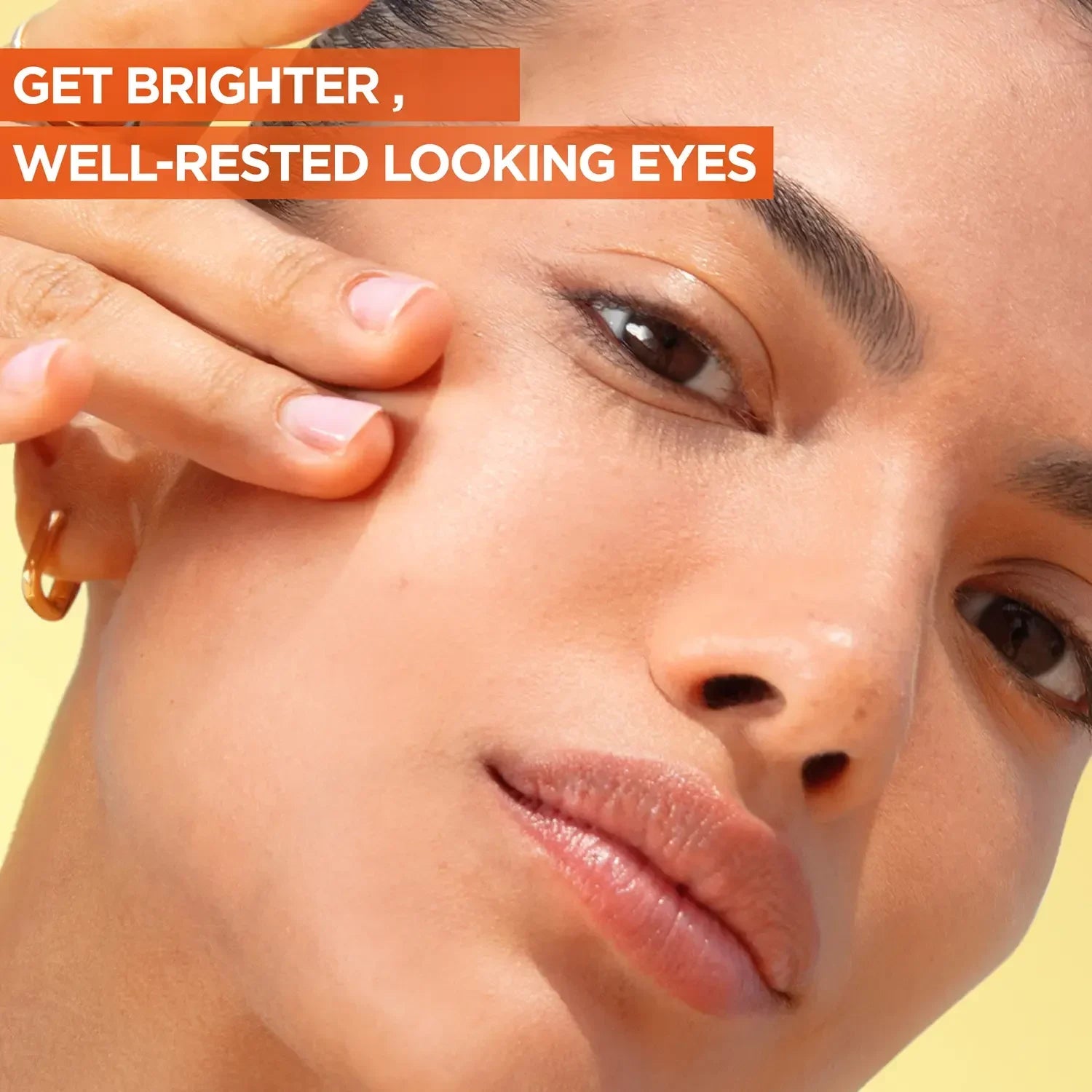 Model applying Garnier Vitamin C Eye Cream to the under-eye area for brighter, well-rested looking eyes and radiant skin.