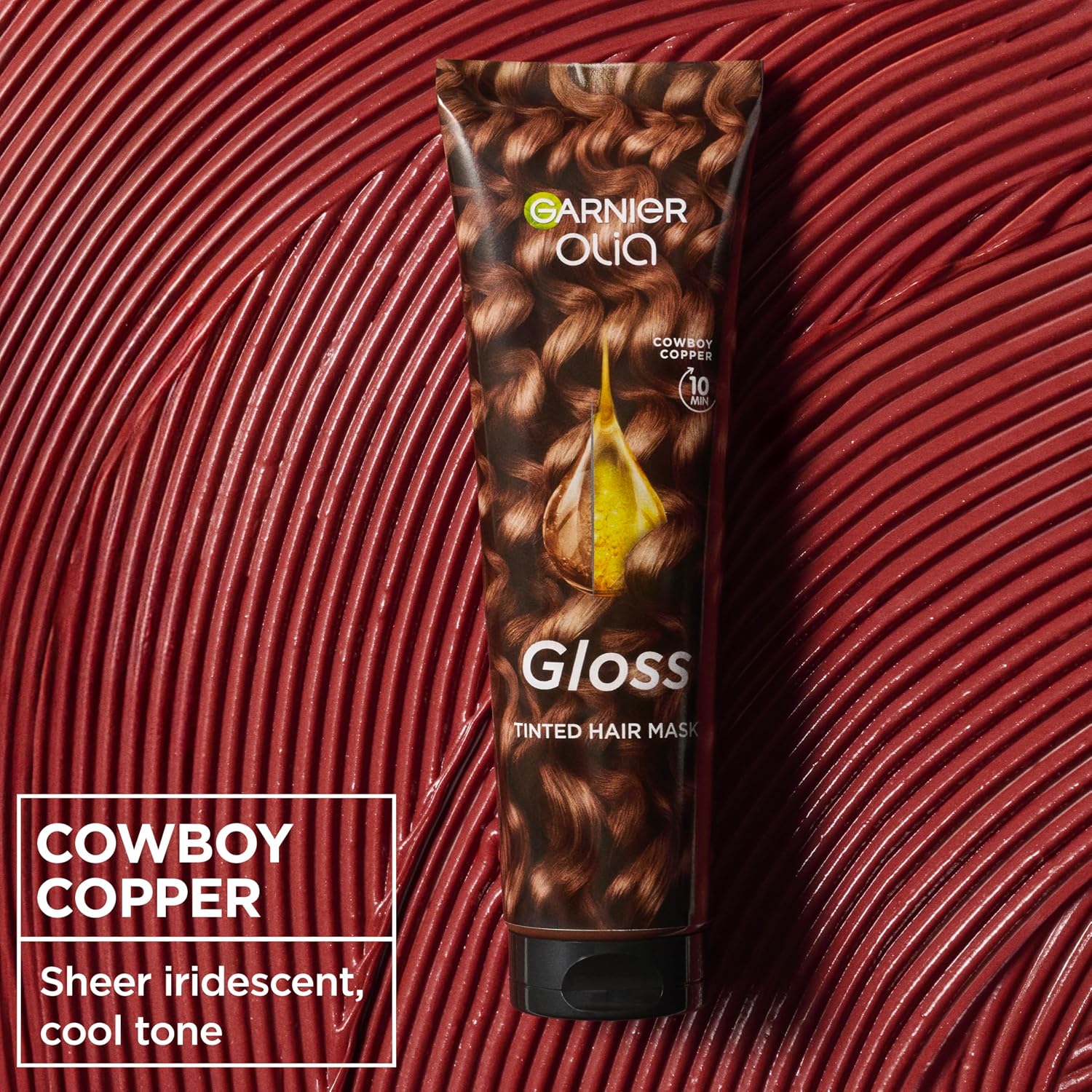 Garnier Olia Gloss Cowboy Copper Tinted Hair Mask 150ml on a glossy red textured background, adding sheer copper colour and mirror-like shine in 10 minutes.