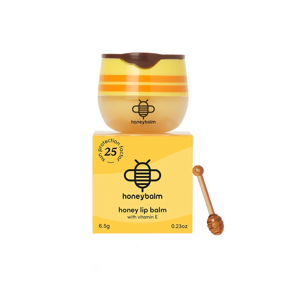 Honey lip balm with packaging and a wooden applicator on a white background
