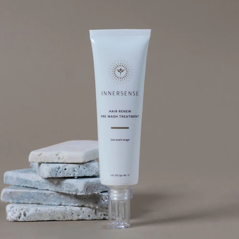 Innersense hair care product with stacked stones on a beige background
