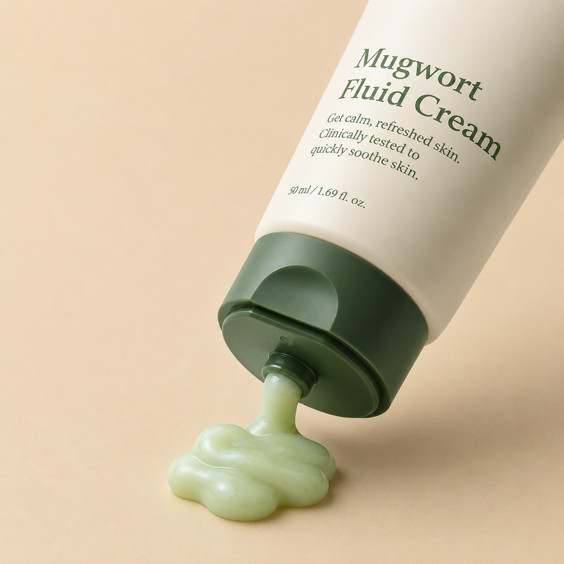 a green tube of Mugwort Fluid Cream lies on a beige background, with light green cream oozing out. the text describes its calming, soothing benefits.