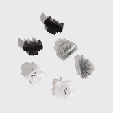 Set of Halloween-themed scrunchies including bats, ghosts, and spider webs on a light gray background.