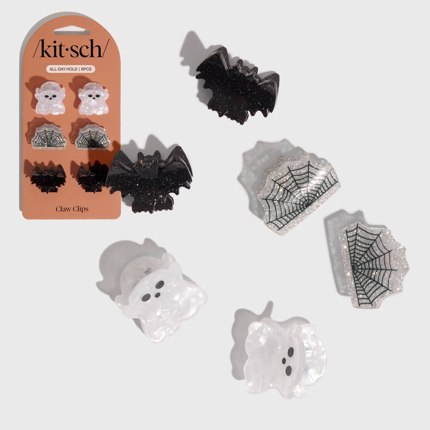 Halloween-themed claw clips with ghost, bat, and spider web designs on a white background.