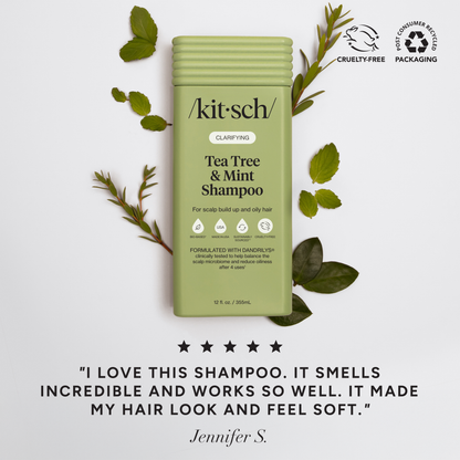 Kit-sch Tea Tree &amp; Mint Shampoo bottle with green leaves on a light gray background