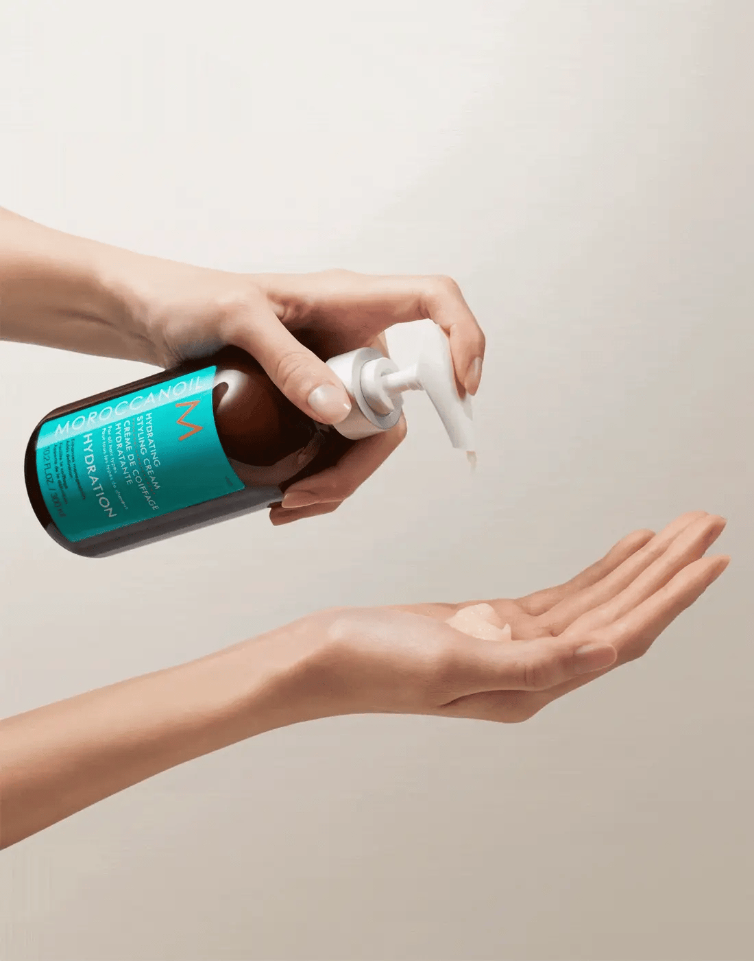 Moroccanoil Hydrating Styling Cream hand pumping cream out