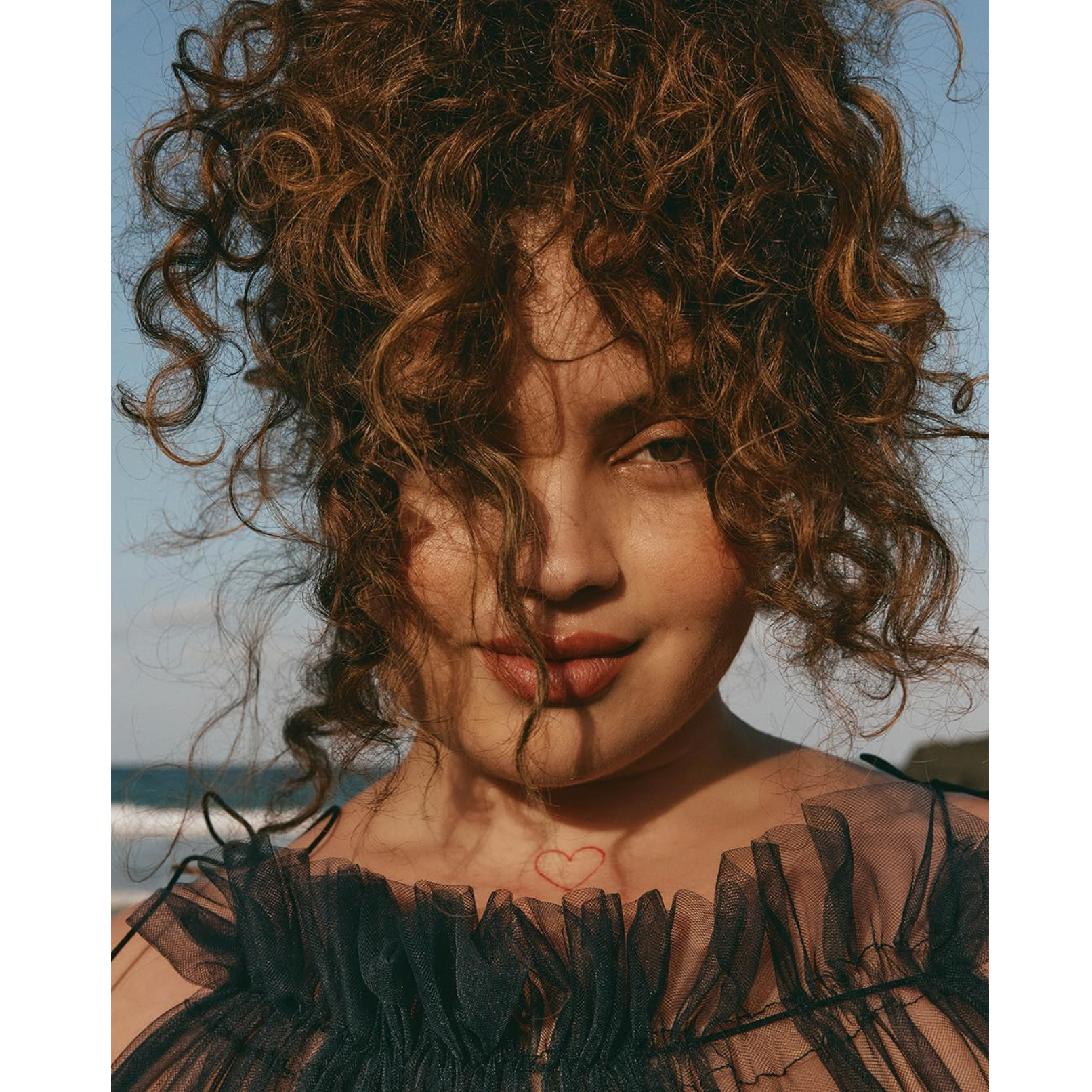 Model with voluminous defined brunette curls representing the hydrated, smooth finish supported by NAK Hair Curl Condition 350ml
