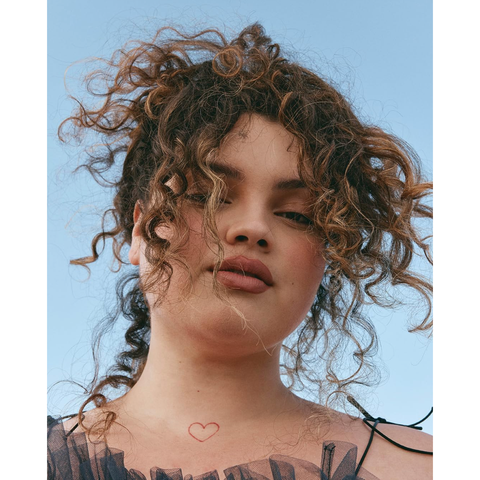 Model with voluminous defined brunette curls representing the hydrated, smooth finish supported by NAK Hair Curl Shampoo 350ml
