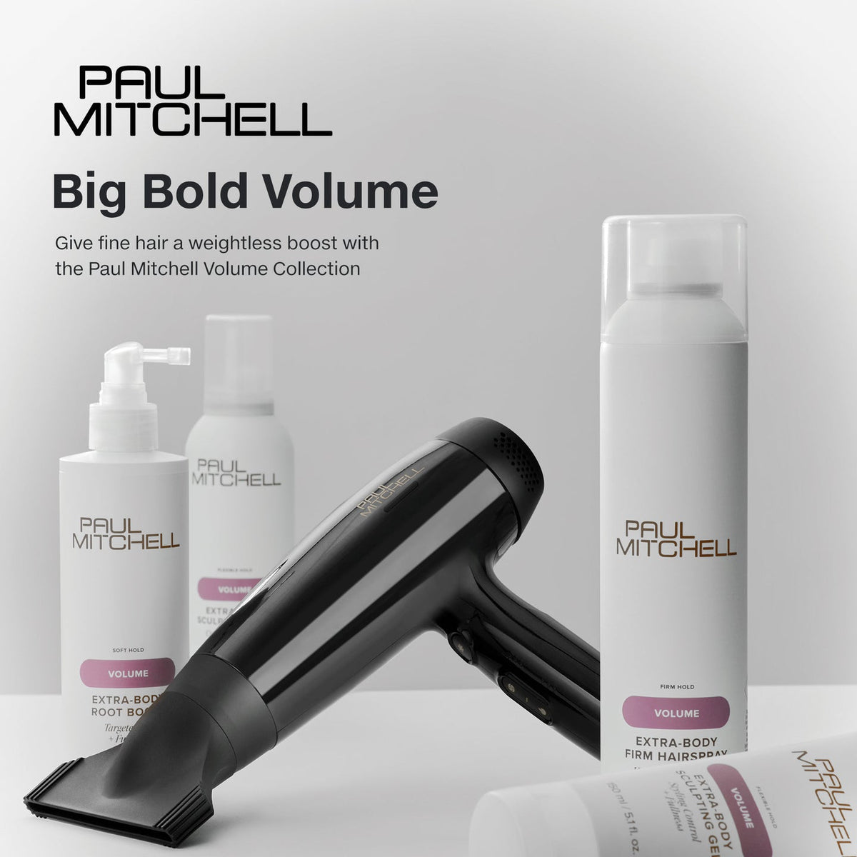Paul Mitchell Volume Collection styling products with a black hair dryer on a grey studio background, designed to give fine hair weightless body and volume.