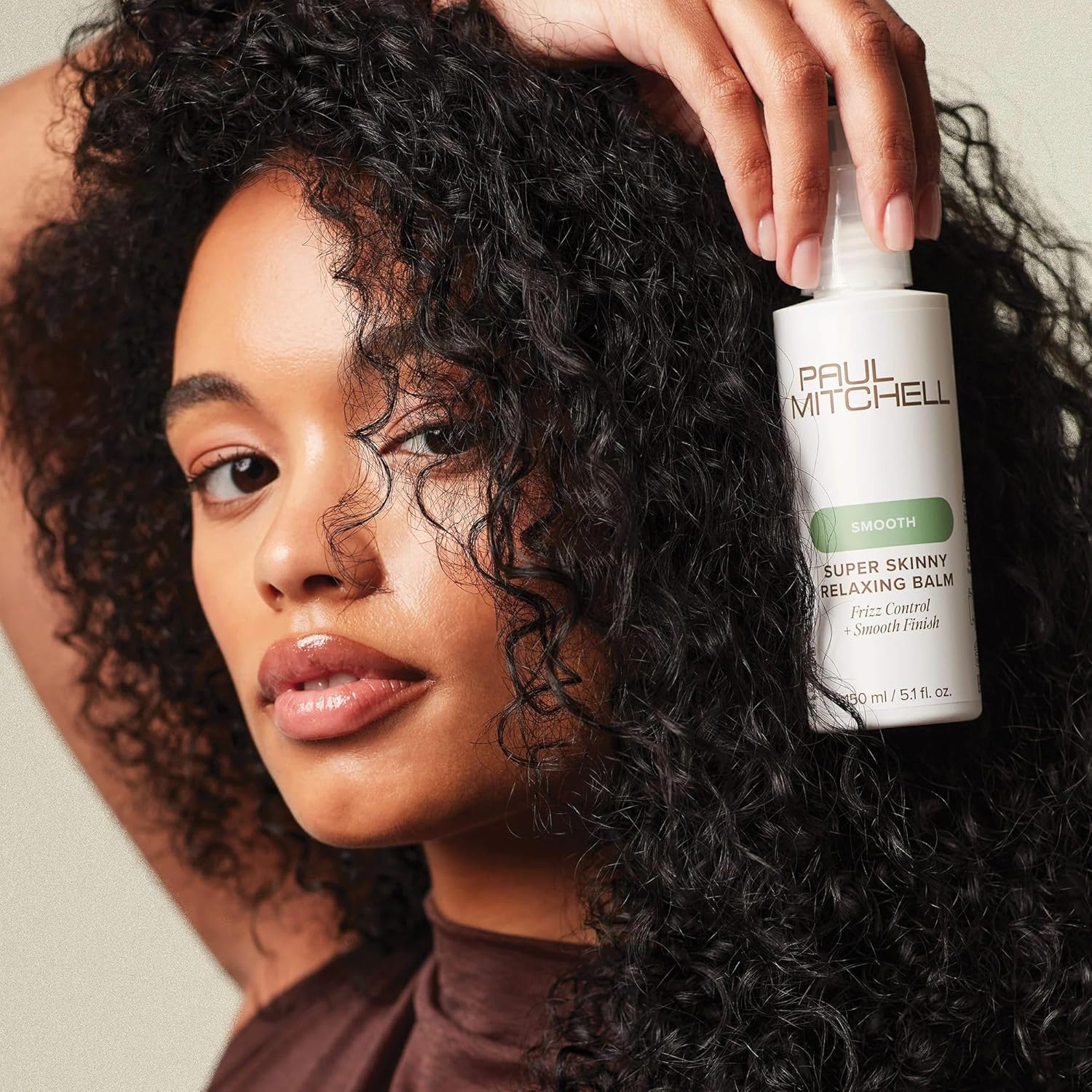 Paul Mitchell Super Skinny Relaxing Balm 150ml model holding product with type 3 hair