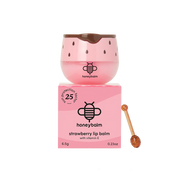 Pink lip balm with strawberry seed design and honeycomb, accompanied by its packaging and a honey stick on a white background.