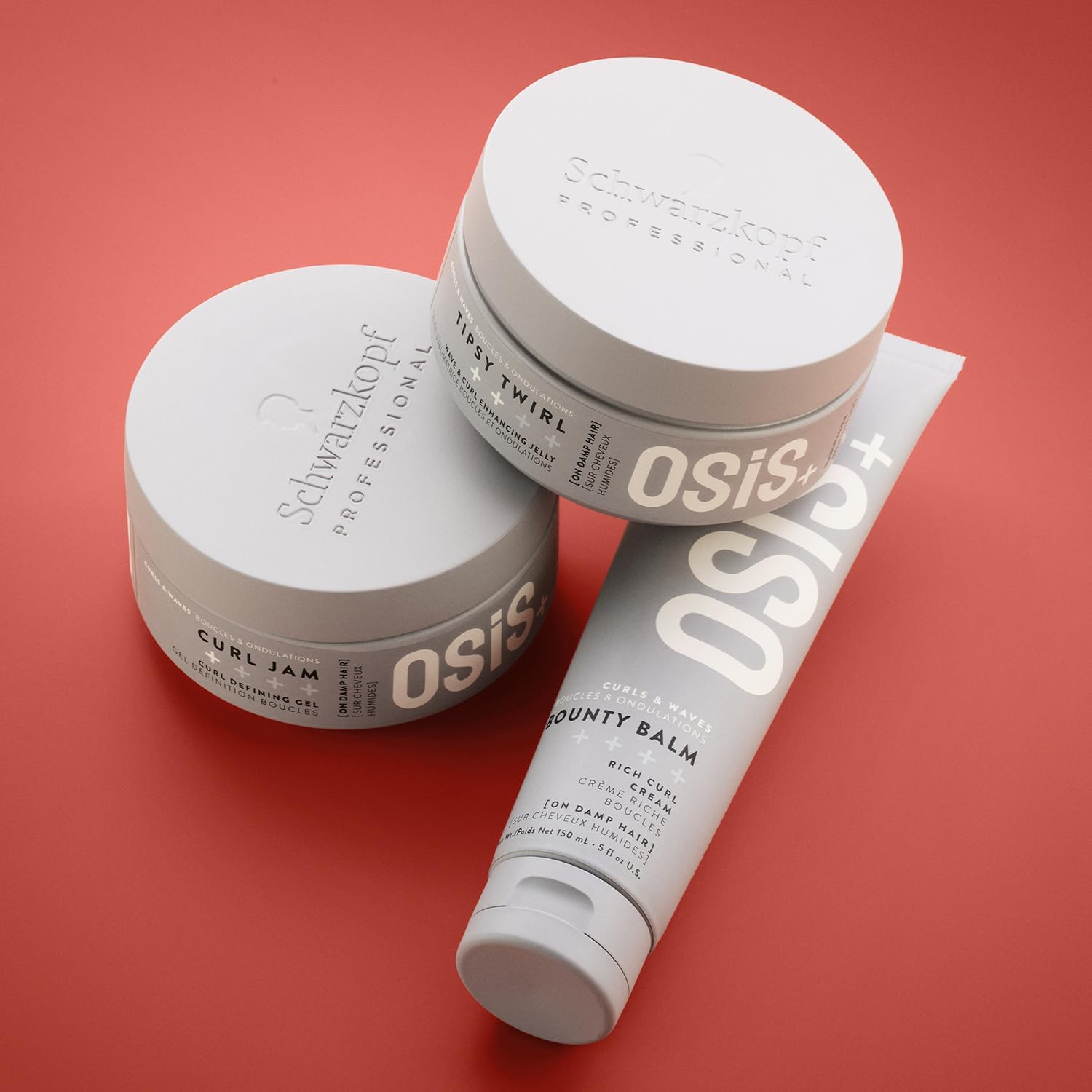 Schwarzkopf Professional OSiS Bounty Balm 150ml displayed with OSiS curl styling gels for curly and wavy hair on a coral background