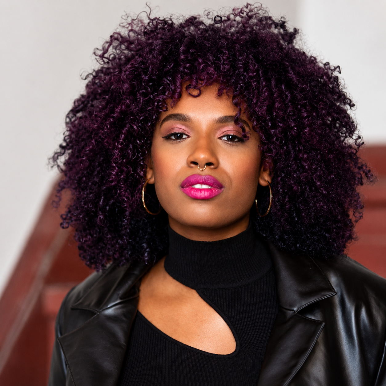 Woman with vibrant Virtual Violet defined curls coloured using Dark & Lovely Fade Resist 421 permanent hair dye for rich, long-lasting colour and brilliant shine